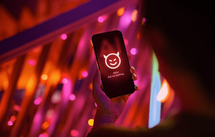 Female hand holding smartphone showing an evil with devil horn on her AI chatbot conversation app in the city. Illustrating the ideas around the risks and dangers of Artificial Intelligence (AI).